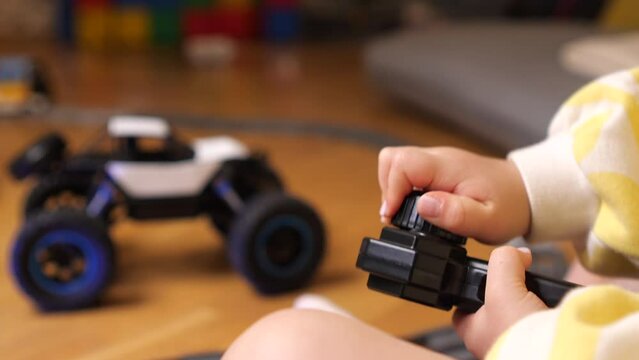 close-up a child turns the control knob from the remote control of a toy car