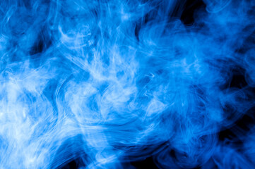 Blue smoke on a dark black background. Beautiful abstract colored background.
