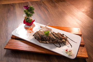 chinese banquet stir fried roasted boneless duck confit with chef special dark sauce in plate on wood table asian restaurant cafe fine dining halal menu