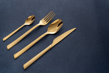 Set of cutlery made of gold metal. Fork, spoon, knife, teaspoon