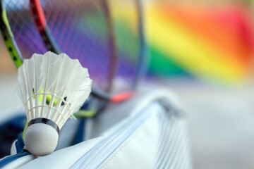 Badminton sport equipments, shuttlecock, rackets in sportbag placed on floor with blurred rainbow...