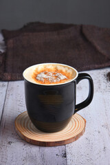 Cappuccino coffee with fresh coffee beans alongside