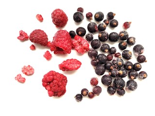Pieces of delicious raspberries and black currant on white background.