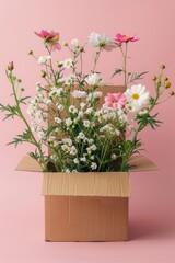 Fototapeta premium A vibrant array of assorted flowers including cosmos and baby's breath arranged in a simple cardboard box against a pink backdrop