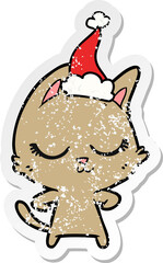 calm distressed sticker cartoon of a cat wearing santa hat