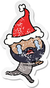 distressed sticker cartoon of a bearded man crying wearing santa hat