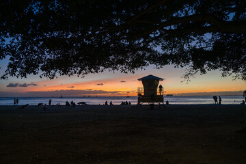 Sunset with silhouettes on a beach in Waikiki Ohau Hawaii.