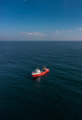 Aerial view to a red fishing vessel in sea