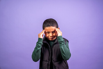 Hispanic boy holding his head with a tension headache