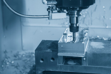 The CNC milling machine chamfer cutting aluminum part by chamfer tool in the light blue scene.