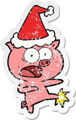distressed sticker cartoon of a pig shouting and kicking wearing santa hat