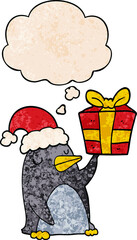 cartoon penguin with christmas present and thought bubble in grunge texture pattern style