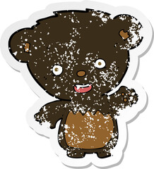 retro distressed sticker of a cartoon black bearcub waving