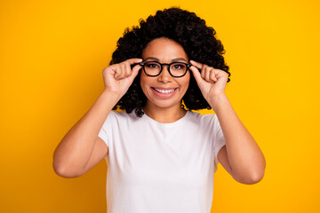 Photo of cheerful positive woman wear white t-shirt arms spectacles smiling isolated yellow color background