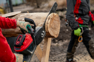 Modern chainsaw working on lumber close up with sawdust flying around