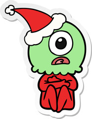 sticker cartoon of a cyclops alien spaceman wearing santa hat