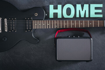 Electric guitar and amplifier on a dark background with decorative word Home.