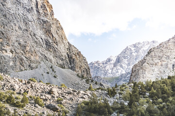 View of the mountain ranges and peaks of the Fan Mountains with glaciers, rocks and vegetation in Tajikistan, mountain panorama on a summer sunny day