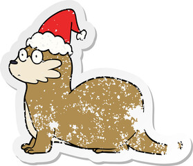 distressed sticker cartoon of a otter wearing santa hat