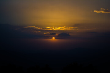 Fototapeta premium Sunset view from the mountains of Lansdowne. Mountain Sunset view in Lansdowne. Amazing golden sunset seen through forest drive, Lansdowne Uttarakhand.