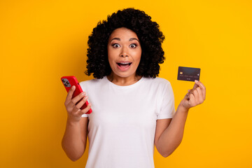 Photo of attractive beautiful impressed woman with chevelure holding smartphone plastic card...