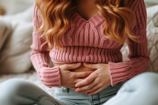 Close up woman's hands touching stomach, stomach pain or abdominal pain. Woman with stomach ache and tired after working. Healthcare concept.