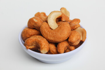 Cashew nut in a white small bowl. isolated on white background
