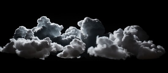 This black and white image showcases clouds against a dark sky, creating a stark contrast. The...