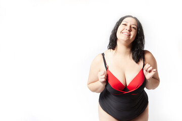 Portrait of attractive dreamy thick woman in red black swimsuit posing on white background. Body positive, photo shoot, selfie. Funny plus size model