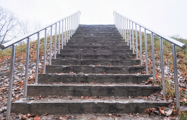 stone staircase up with metal railings in autumn