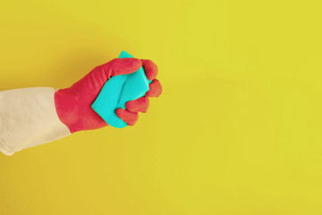 Hand in a rubber glove holds a sponge