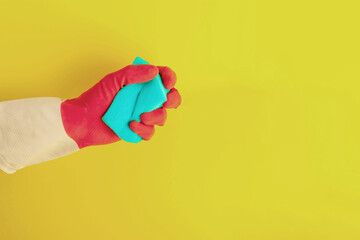 Fototapeta na wymiar Hand in a rubber glove holds a sponge