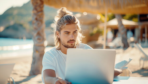 Handsome young man sitting on open terrace hut-style cafe on the tropic island exotic beach with modern laptop. Digital nomads lifestyle, remote working, blogging, stocks trading concept image.