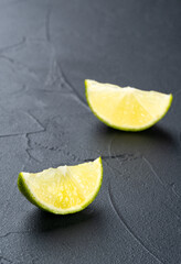 Two juicy halves of lime fruit on a dark background
