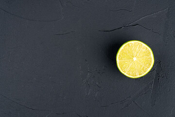 Juicy half of a lime fruit on a dark background