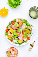 Fresh delicious shrimp salad with orange, lettuce, tomatoes, cucumbers, onions and sesame seeds...
