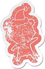 laughing teddy  bear cartoon distressed sticker of a wearing santa hat