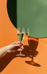 Hand holding a champagne glass next to a mirror. Drinking buddies, social distancing background. - 751594303