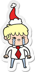 sticker cartoon of a boy crying wearing santa hat