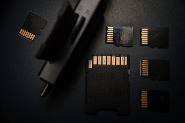 Black USB card reader surrounded by SD cards.