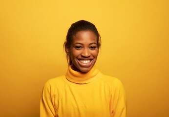 Close up portrait of beautiful young african woman laughing over yellow background