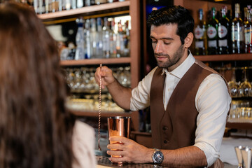 Man bartender is making a drink and dancing at bar. Dance party with group people dancing . Women and men have fun and drinking martini cocktail in night club.