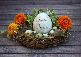 Grußkarte Frohe Ostern: Harmonische Osterdekoration mit Ostereiern in einem Nest, davon eins mit dem Text Frohe Ostern beschriftet.