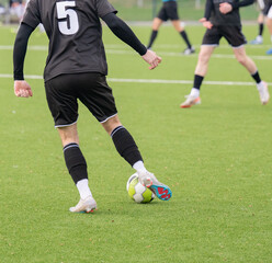 Fußballspieler, die dem Ball hinterherlaufen