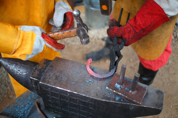 Process of forging iron red-hot horseshoe on anvil billet in smithy