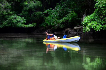 Absorded the touch of nature. That man take a nap on his kayak that's quietly floated and surrounded by the mangrove forest.