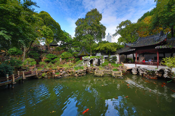 Beautiful pond and old buildings in China garden, walking tourists, HDR