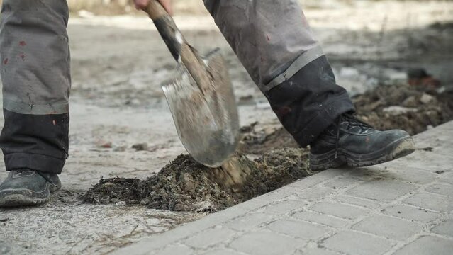 Worker Digs electric wires into the ground with a Shovel	
Man digs a ditch in the ground with a shovel