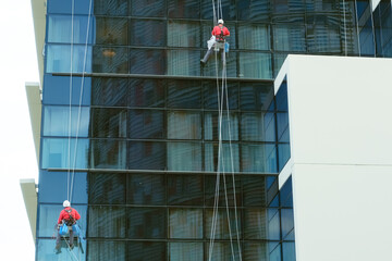 industrial climbers washing glass office building facade