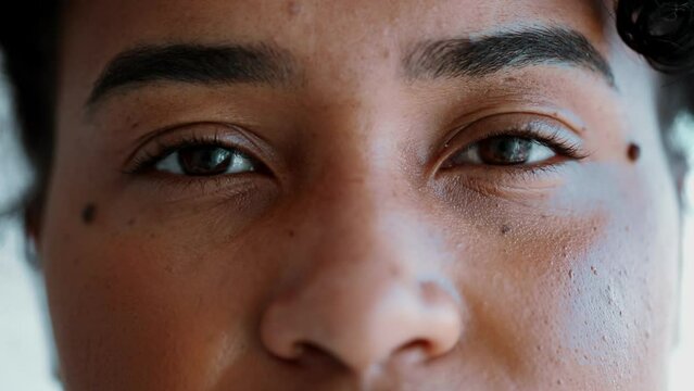 Macro close-up eyes of South American woman of African descent gazing at camera, facial detail eye with neutral expression